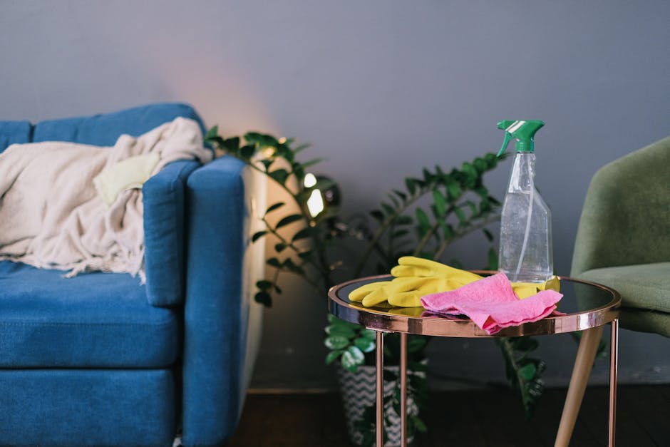 A tastefully decorated living room featuring a plush dusty rose sofa adorned with five decorative cushions in shades of beige and gray. In front of the sofa, there is a white rectangular coffee table 